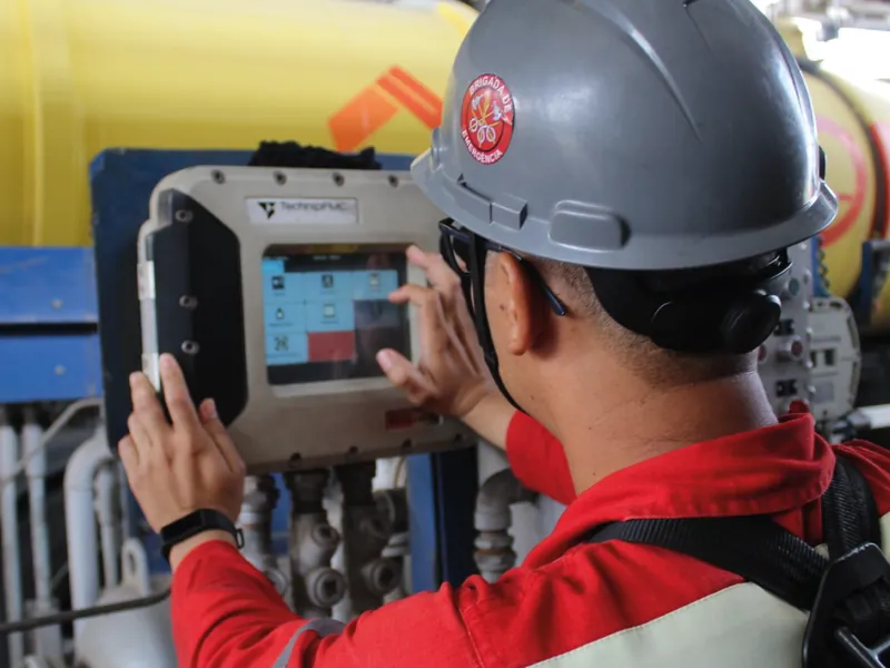 Operador do TECAB com equipamento de proteção utilizando painel de controle